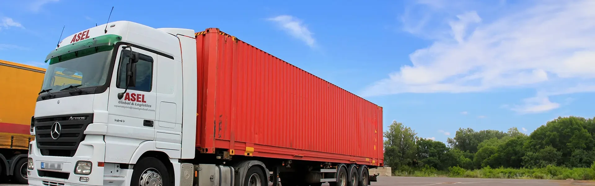 A large truck with a red trailer, featuring a picture that says Container Transportation
