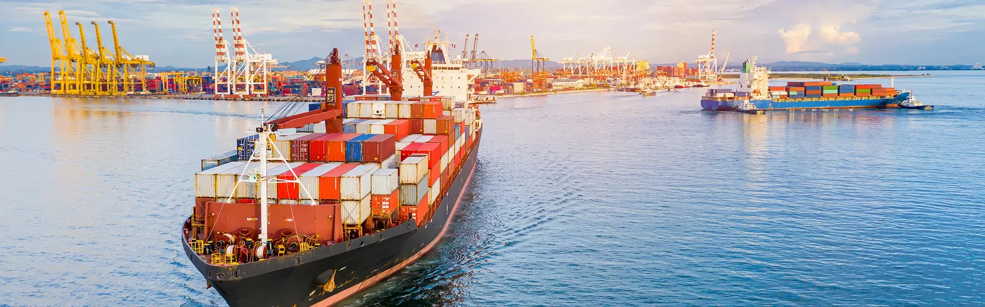 In the middle of the sea, there is a large container ship with the inscription "Sea Transportation" on it