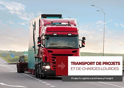 Un camion rouge avance sur l'autoroute avec une lowbed portant l'inscription "Transport de projets et de charges lourdes"